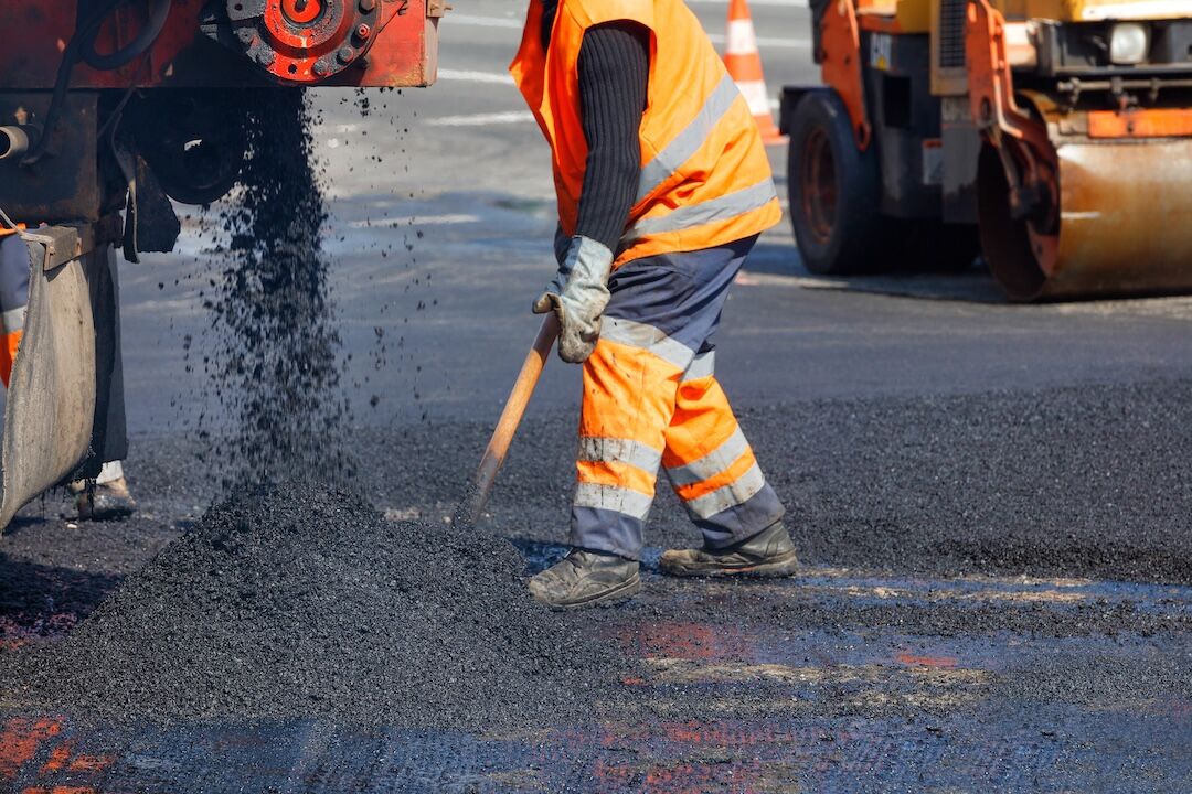 Crew shoveling asphalt for a repair in Dallas–Fort Worth, TX — Blackland Asphalt