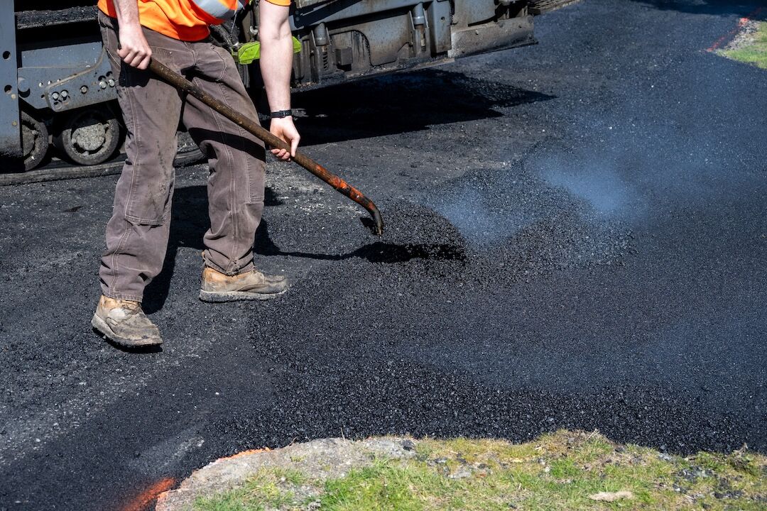 Worker compacting a blacktop patch in Dallas–Fort Worth, TX — Blackland Asphalt